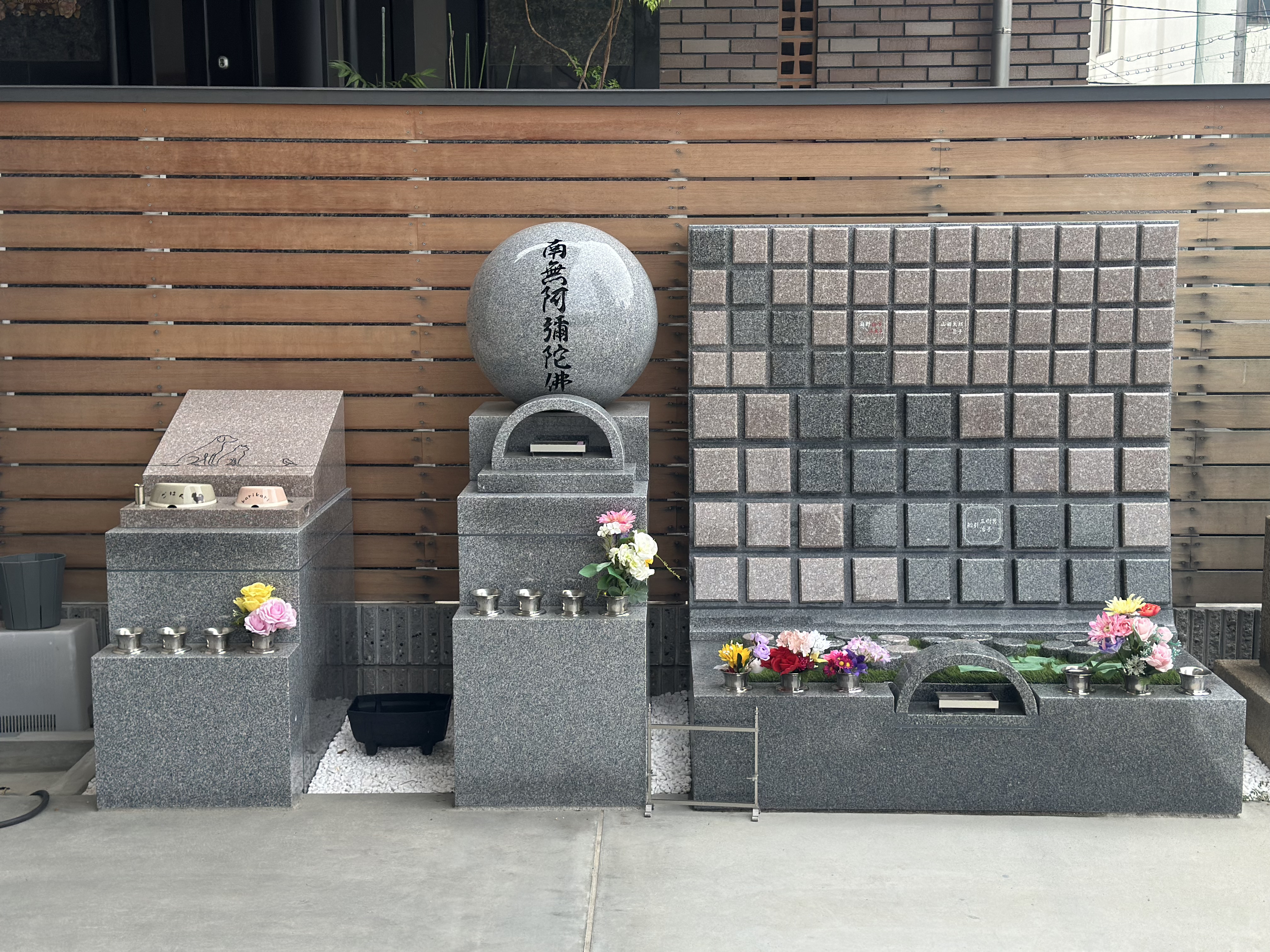 「南無阿弥陀佛」の球体を中心とした合祀墓と樹木葬の区画壁